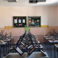 Sală de clasă goală, cu scaunele puse pe bănci